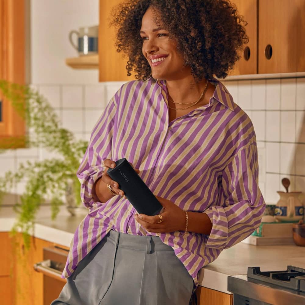 Person holding a Sonos Roam 2 in Black in the kitchen